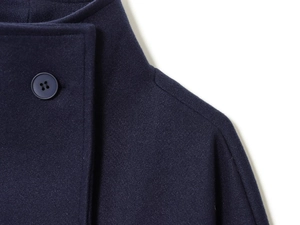 Close-up of navy blue double-breasted wool coat showing fabric texture and round button