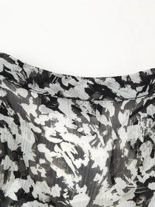 Close-up of black and white ink floral print dress with pleated chiffon fabric texture