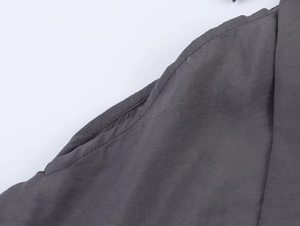 Detail shot of deep gray knit coat featuring reinforced side pocket and premium stitching