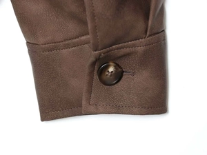 Detail der braunen Wildlederjacke Manschette mit einem Marmorharzknopf in Premiumqualität