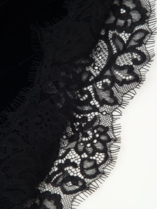 Détail de dentelle florale noire délicate sur un tissu de robe en velours premium