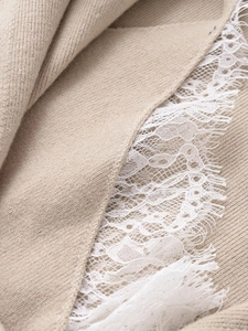 Detail of oatmeal ribbed knit fabric with delicate white eyelash lace trimming