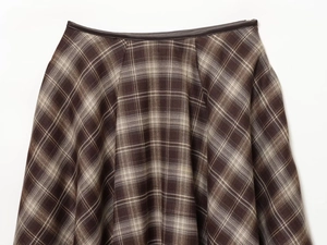Détail de la taille d'une jupe trapèze à carreaux marron avec tissu texturé et couture