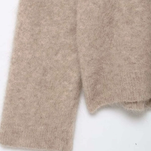 Nahaufnahme von weichem Alpaka-Strickpullover in Beige mit flauschiger Textur und Fasern