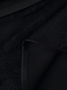 Detailed macro view of black floral lace fabric with delicate eyelash trim texture