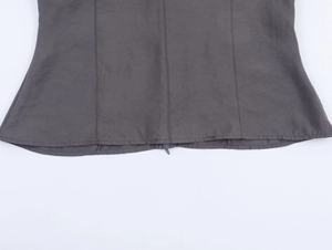 Detail of dark grey knit coat featuring visible seam stitching and concealed zipper hem