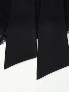 Detail shot of elegant black eyelash lace and silky ribbon straps on a minimalist top