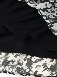 Detail of double-layer dress with monochrome marble print and pleated chiffon fabric
