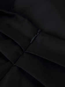Detailed macro view of the invisible black zipper and pleated satin fabric texture