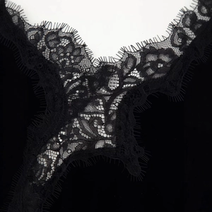 Détail élégant de dentelle florale noire sur une robe en velours avec broderie fine