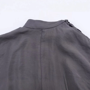 Deep charcoal gray knitted coat with split sleeves showing detailed collar stitching