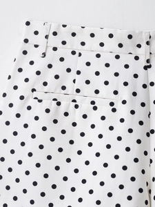 Détail d'un short à pois avec poche passepoilée et passants de ceinture sur tissu coton