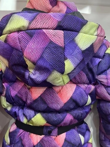 Détail de l'imprimé texture tressée colorée et de la ceinture noire de la veste de ski