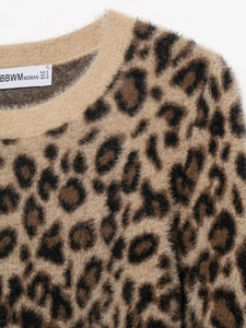 Detail of leopard print faux fur knit sweater showing plush texture and neck label