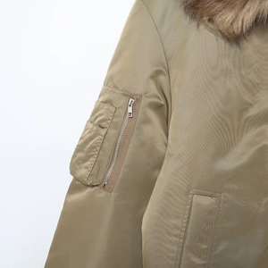 Detail of bomber jacket sleeve with zipper pocket and faux fur collar on khaki fabric