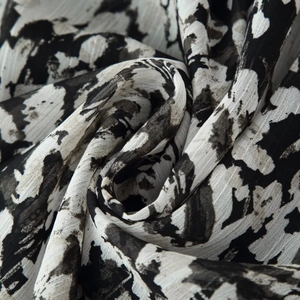 Fashionable mini dress featuring black and white marble print fabric and matching belt detail