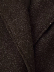 Macro shot of dark brown wool coat collar showing dense fabric texture and stitching