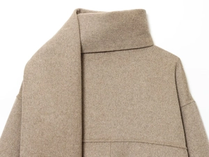 Detail shot of camel wool coat with soft brushed texture and minimalist high-neck design
