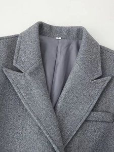 Detailed close-up of notched lapels and grey wool texture on double-breasted coat