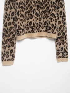 Detailed close-up of fluffy leopard print knit fabric with soft faux fur texture