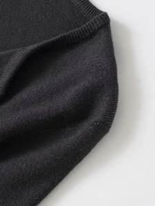 Close-up of charcoal grey knit top featuring delicate lace splicing and ribbed neckline