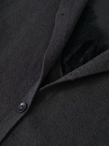 Close-up of charcoal grey knit cardigan with black eyelash lace trim and buttons