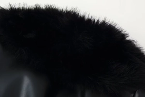 Détails de la bordure en fausse fourrure noire et cuir texturé d'une veste d'hiver