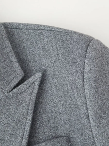 Detail of gray wool coat collar and shoulder featuring thick textured fabric and lapels