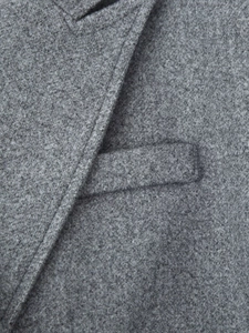 Detail of dark grey wool coat showing high-quality stitching and textured fabric finish