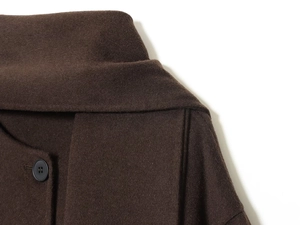 Close-up of deep brown wool coat texture with collar detail and round button