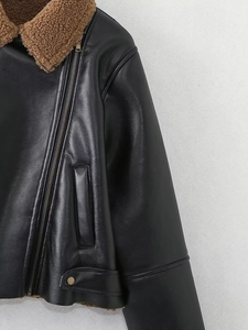 Detail of black faux leather biker jacket with brown faux fur collar and metal zipper