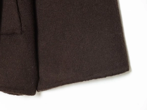 Detailed macro view showing the thick dark coffee wool fabric and fine stitching on the coat