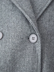 Detail of wool blend coat fabric with classic lapel and dark gray resin button