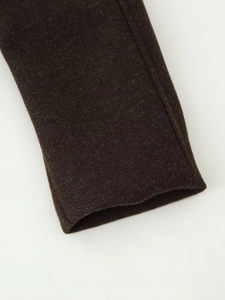 Detailed close-up of dark wool coat cuff with neat stitching and premium fabric texture