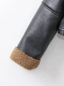 Detailed close-up of faux leather texture and brown shearling lining on jacket sleeve