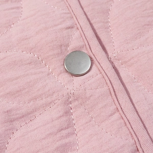 Macro shot of pink quilted jacket detailing with round silver metal button