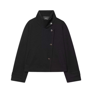 Détail d'une veste en laine noire avec col montant, boutonnage oblique et étiquette de marque