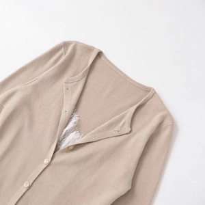 Elegant beige knit cardigan featuring delicate white lace collar and round buttons