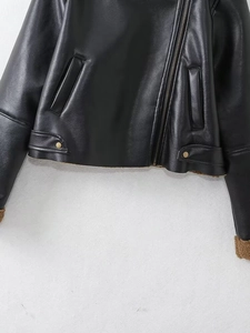 Close-up of black faux leather biker jacket featuring brown faux shearling lining details