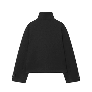 Détail d'une veste courte en laine noire avec col montant et sangles de poignet réglables