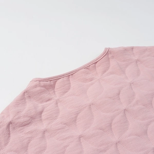 Close-up of pink quilted jacket collar featuring delicate petal-shaped stitching detail