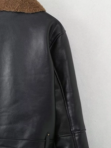 Detail of stitching and leather texture on a vintage black motorcycle jacket with fleece