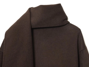 Detailed close-up of dark coffee wool coat lapel with thick premium fabric texture