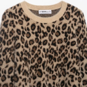 Faux fur leopard print knit sweater with soft texture and brand neck label detail