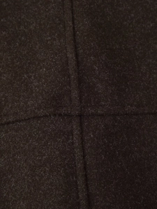 Detailed view of dark brown wool fabric texture with high-quality cross-stitching craft