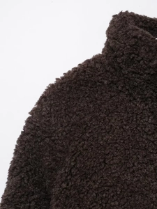 Nahaufnahme der dunkelbraunen Teddy-Fleece-Struktur und Stehkragen-Details der Jacke