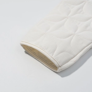 Detailed macro view of diamond quilted white jacket cuff with clean stitching lines