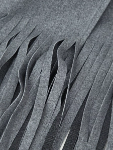 Detail of grey wool coat showing high-quality fringed hem and thick fabric texture