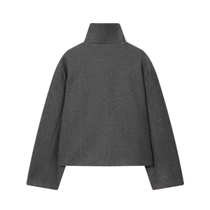 Gros plan sur une veste courte gris foncé avec col montant et texture laine premium