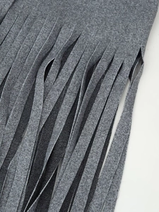 Detail of grey woolen coat showing neat fringe hem and premium fabric texture